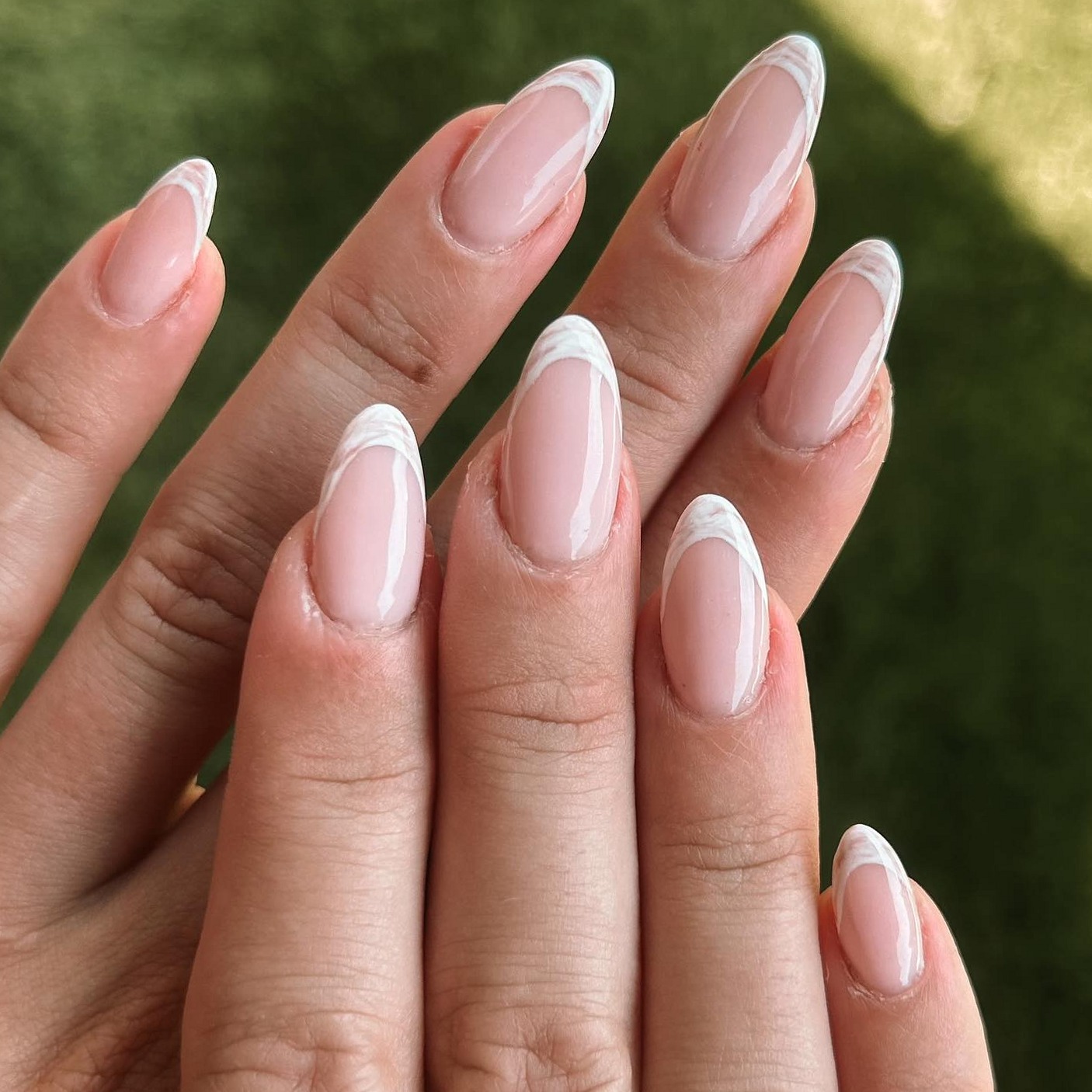 Amandelvormige nagels met een witte french en schelpenpatroon, gezet bij LNailed it!